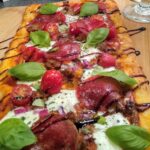 Fette di salame piccante stratificate con mozzarella fresca